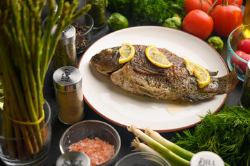 Grilled fish with fresh vegetables, on a wooden black background. I also eat healthy food. Seafood