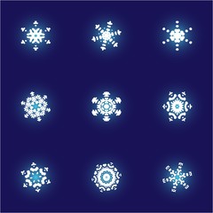 Set of isolated falling snowflakes on blue background.