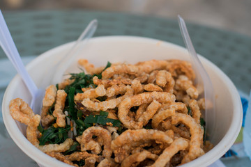 Close up image spicy rice noodle salad in a foam cup topped with pork curry  And with a plastic cutlery plugged in