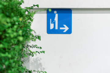 Blue sign  It is a sign to go to the men's bathroom that is stuck on the wall.