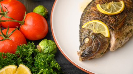 Ready cooked fish on a background with vegetables. Cooking recipes, restaurant business, culinary recipes