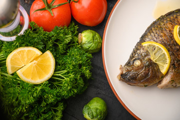 Ready cooked fish on a background with vegetables. Cooking recipes, restaurant business, culinary recipes