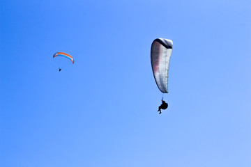paraglider flying in blue sky on valleys landscape in Indonesia