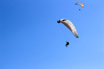 paraglider flying in blue sky on valleys landscape in Indonesia