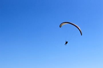 a paraglider flying in blue sky landscape in Indonesia