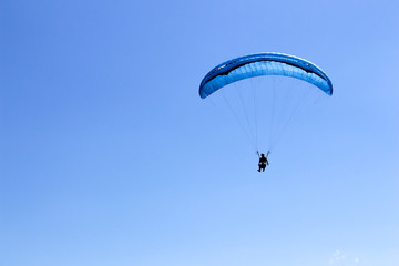 a paraglider flying in blue sky landscape in Indonesia