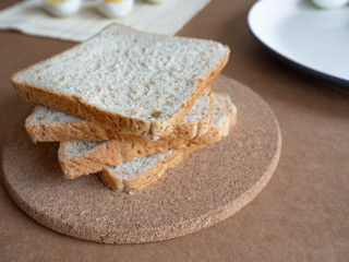 ฺBoiled egg topped with Cayenne pepper Pepper and Salt on a white dish,Egg colors white and yellow,Eat with bread