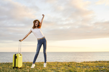 young woman with suitcase on country road