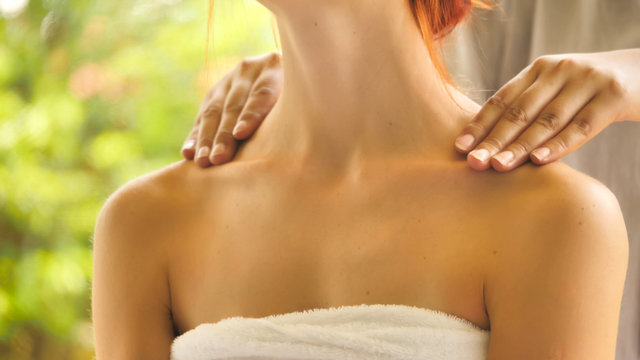 Attractive woman getting shoulder massage at spa.