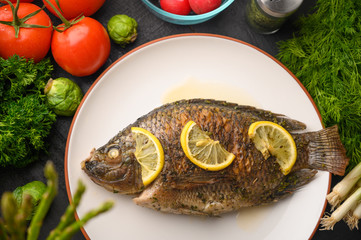 Stewed fish with lemons and fresh vegetables. Delicious and healthy food.