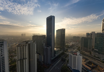 kuala lumpur with large tower building silhouette with dramatic sunrise