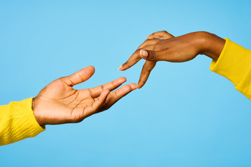 hand of man and woman holding hands against blue sky