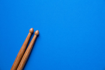 Drum stick on blue table background, top view, music concept