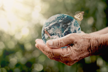 The old woman's hand is holding a globe.