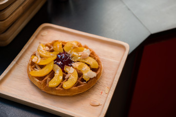 waffles with peach put on wooden plate