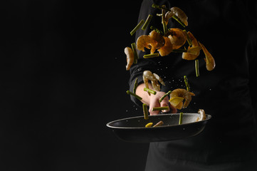 Seafood, shrimp frying, chef on a black background