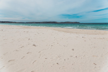 Spring beach in Tasmania, Australia looking pristine and deserted with white sand and turquoise water
