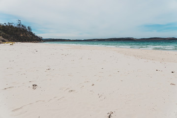 Spring beach in Tasmania, Australia looking pristine and deserted with white sand and turquoise water