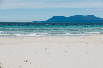 Spring beach in Tasmania, Australia looking pristine and deserted with white sand and turquoise water