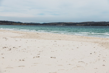 Spring beach in Tasmania, Australia looking pristine and deserted with white sand and turquoise water