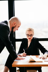 Businessman and woman discussing documents and coworking at the office meeting. Partners working on new project. Professional cooperation