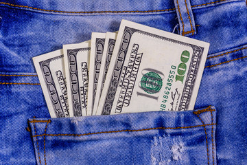 American one hundred dollar banknotes in a pocket of blue jeans