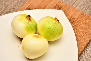 cebolla blanca servida en plato blanco sobre mesa de madera