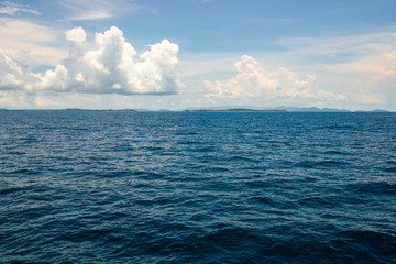 The deep ocean view with the yellow sunlight and cloudy sky