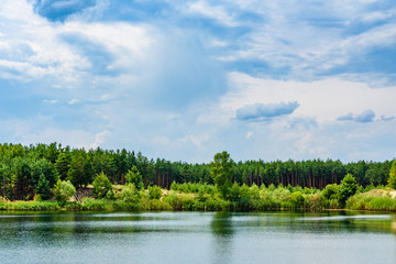 View on a lake in the abandoned sand quarry and dramatic sky