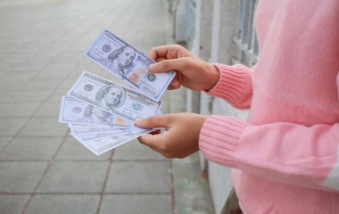 Hand counting 100 dollars cash banknotes, bonus or commission extra money in end of festival for working woman, micro job or online shopping seller in digital marketing concept or cash flows