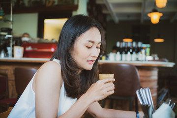 Asian business women drinking latte coffee sitting in cafe