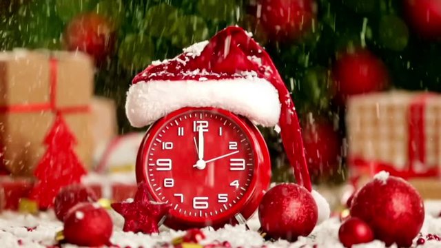 Alarm clock with falling snow and Santa Claus hat. Christmas countdown concept