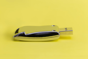 Metallic pen drive on a yellow background