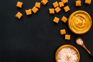 Popular sweets. Salted caramel on black background top view copy space