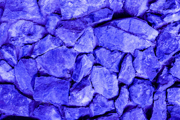 Background texture of a blue purple stone on the rock of the mountain discovered during archaeological excavations as a monument to millions of years of the formation of cancerous deposits under water