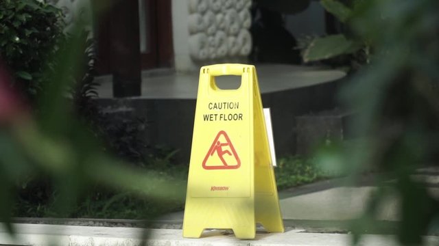 A yellow sign informing to take attention on a wet floor "Caution wet floor"