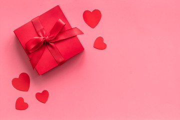 Gift to a sweetheart on Valentine's Day. Red present box near hearts on pink background top-down copy space