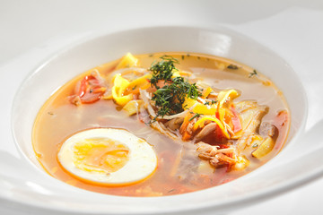 Chicken Soup with Tagliatelle Pasta, Eggs and Fresh Herbs Isolated