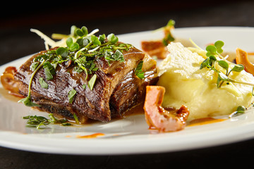 Beef brisket and mashed potato on white plate