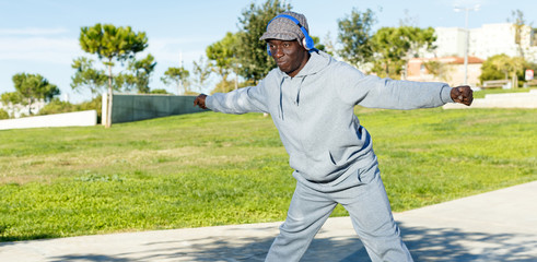 Athletic african  american male performs warm-up exercises in park