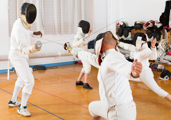 Fototapeta premium Mixed age group of athletes at fencing workout
