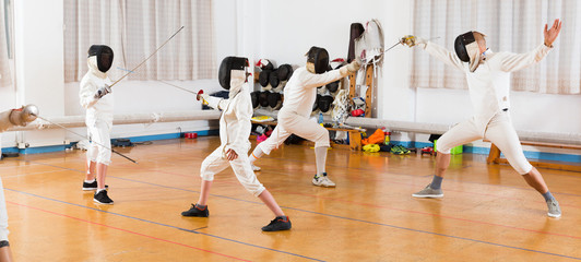 Mixed age group of fencers at  workout