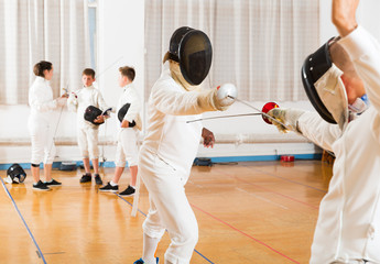 Young fencers training with coach