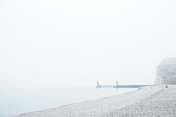 The lighthouses that form a beacon in the port of Fecamp, Normandy, France on a grey and misty day