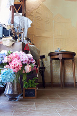 IZMAIL, UKRAINE - June 15, 2019: Fragment of cozy interior of a vintage cafe with brown oak wooden tables and chairs and textile toys