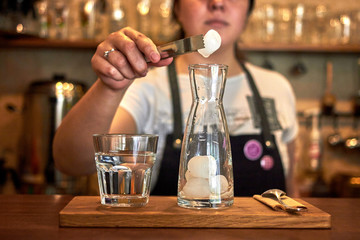 Fototapeta na wymiar Barista woman prepares cold brew coffee in glass bottle in the coffee shop