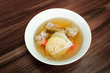 Cabbage clear soup with minced pork (Thai clear soup with vegetable) on dark brown wooden table.