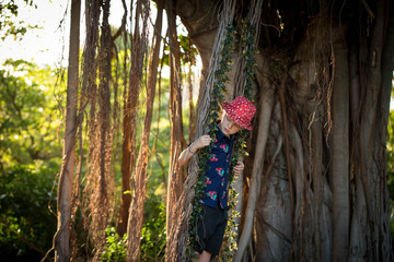 Young caucasian boy playing on swing covered in mistletoe for Christmas picture