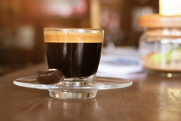 Glass of espresso on wooden table with copy space.