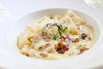Fettucine carbonara pasta with fried bacon and grated cheese. Carbonara is an Italian pasta dish from Rome made with egg, hard cheese, pancetta and pepper.